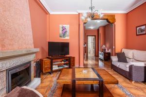 a living room with a fireplace and a tv at Quintanal de Villacarriedo in Villacarriedo