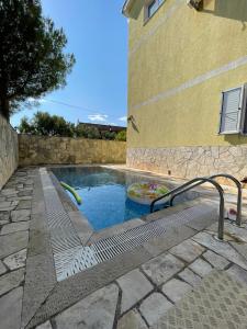 a pool with a slide in front of a building at Apartments Villa-G Lustica in Tivat