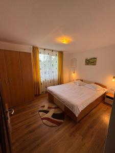 a bedroom with a large bed and a wooden floor at Casa Mariei in Vama Buzăului