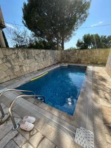 a swimming pool with a stone wall and a swimming pool at Apartments Villa-G Lustica in Tivat