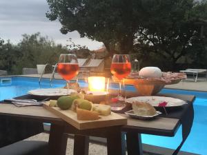 a table with two glasses of wine and cheese at Etna Petit Relais in Nicolosi