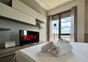 a bedroom with a tv and a bed with towels at - ARENA - Panoramic VIEW - Central Apartment in Verona