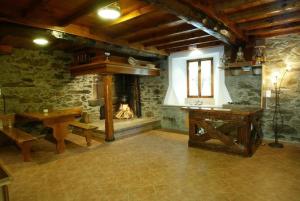 a room with a table and a stone fireplace at Costa da Egoa in Carral