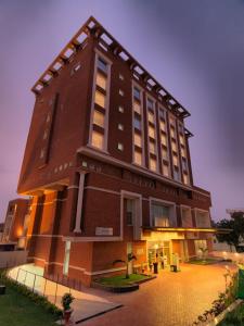 a large brick building with aventh floor at Hotel Royal Orchid Jaipur, Tonk Road in Jaipur