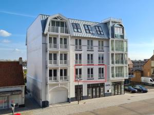 an apartment building with a white facade at Lichthuys 102 in Cadzand