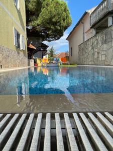 a swimming pool with a bench next to a building at Apartments Villa-G Lustica in Tivat
