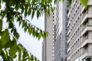 a tall apartment building with the sign for the hotel at SR Hotel Yeongjong in Incheon