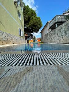 an empty swimming pool next to a building at Apartments Villa-G Lustica in Tivat