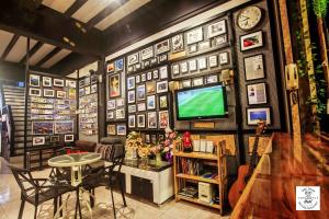 a room with a tv and a table and chairs at โฟโต้โฮสเทล เบตง Foto Hostel Betong in Betong