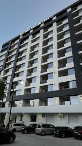 a large apartment building with cars parked in front of it at Marina studio in Mamaia Nord