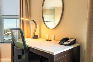 una scrivania con telefono e specchio di Holiday Inn Express Savannah - Historic District a Savannah