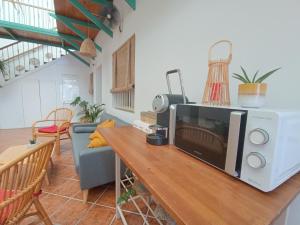 a living room with a microwave and a table at Hostal Cristina in Chipiona