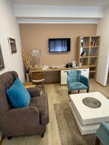 a living room with a couch and a table and a tv at Gardenia Hotel & Spa in Veles