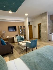 a room with a bed and a desk and a couch at Gardenia Hotel & Spa in Veles
