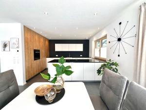 a kitchen with a table and a clock on the wall at Ferienhaus Sarah in Lechbruck