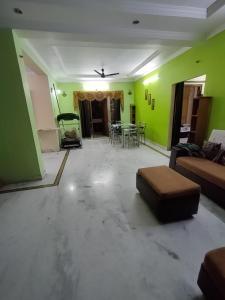 Una sala de estar con paredes verdes y un sofá. en Rendezvous, en Hyderabad 19 fotos más
