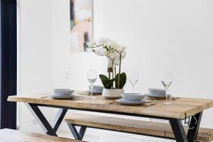 une table en bois avec des assiettes et des verres dans l'établissement The Oakleigh - Fosse Park - Close to M1 and M69 - 3 Bed House, Contractors, Corporates, MonthlyStays, à Glen Parva 18 autres photos