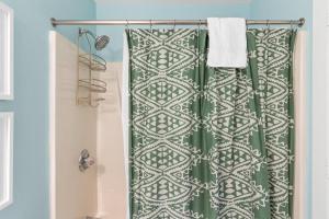 a shower with a green and white shower curtain at Seaside Passage in Southport +32 photos