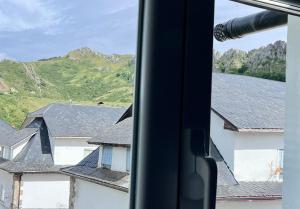a view of houses and mountains from a window at La Casa del Minero in Olleros de Sabero