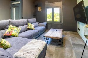 a living room with a couch and a coffee table at Black House- Sorprendente casa estilo industrial in Olot
