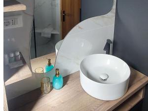 a bathroom with a white sink on a wooden counter at Apartmani Katarina in Makarska +68 photos