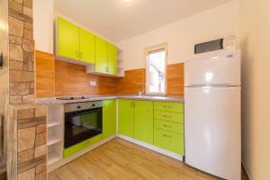 a kitchen with green cabinets and a refrigerator at Rekreační chata Val in Veselí nad Lužnicí