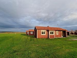 a small house in a field with a green field at Burträsk Camping & Stugby in Burträsk