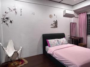 a bedroom with a bed and a chair in it at Terap Homestay 500MB Wi-fi in Sibu