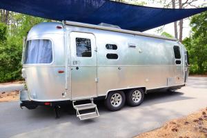 a silver trailer is parked under a tent at Ziggy's Place in Wilmington