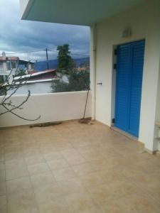a balcony with a blue door and a view of the ocean at Angel in Káto Alepokhórion