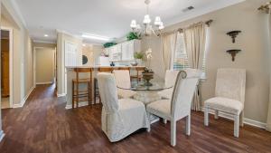 a dining room with a glass table and chairs at 41A 10th Hole at True Blue condo by Peace Vacations in Pawleys Island +16 photos