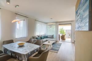 a living room with a table and a couch at Blue Apartman Szántód in Szántód