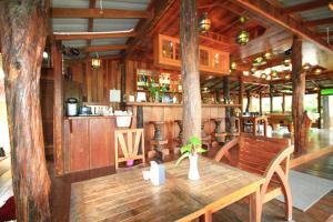 クラビタウンにあるJ.Holiday Inn Krabiの木製のテーブルとバーのある木造レストランを併設しています。
