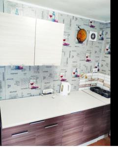 a kitchen with a white counter top with paper on the wall at Гостевой дом золотые пески in Zatoka +14 photos
