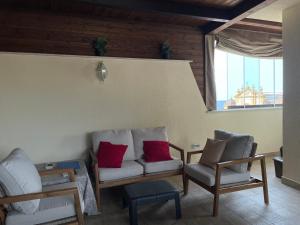 a living room with two chairs and a couch and a window at Suite de la Sicilienne in Castellammare del Golfo