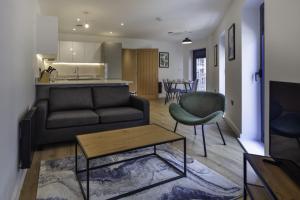 a living room with a couch and a table and a kitchen at Fantastic 2 Bedroom Apartment in Central Ashford in Ashford