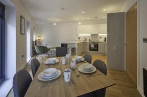 a dining room table with chairs and a kitchen at Fantastic 2 Bedroom Apartment in Central Ashford in Ashford