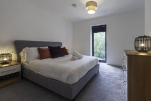 a white bedroom with a bed and a window at Fantastic 2 Bedroom Apartment in Central Ashford in Ashford