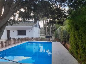 una piscina blu di fronte a una casa bianca di Villa Emilia 2 a Ossa de Montiel