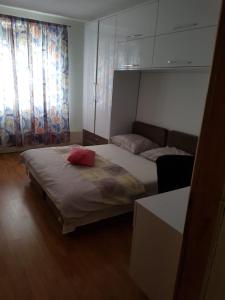 a bedroom with a bed with a red pillow on it at Villa Ilidza فيلا إليدزا in Ilidza