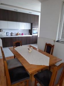 a dining room table with chairs and a kitchen at Villa Ilidza فيلا إليدزا in Ilidza