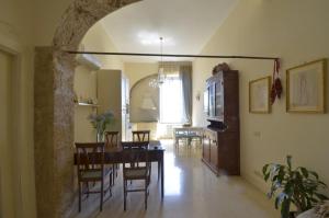 a dining room and living room with a table and chairs at Domus Ponte casa antica ed elegante in pieno centro storico in Arpino