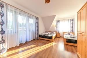 a bedroom with two beds and a window at VillaGiewont in Kościelisko