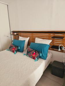 una camera da letto con un letto con cuscini blu e bianchi di ALIZENZO a Le Diamant Altre 20 foto