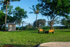 twee parkbanken in een park met een speeltuin bij Signature Collections by Eight Continents in Utende +62 foto's