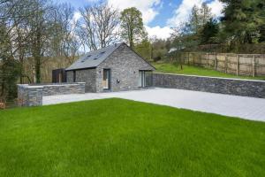 una casa de piedra con césped verde en Fawns Keep, en Bowland Bridge