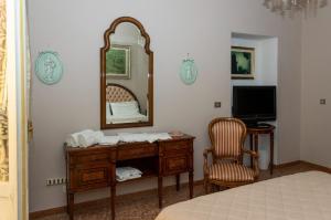 a bedroom with a mirror and a desk with a chair at La Casa di Paola in Graffignano