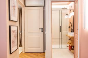a bathroom with a white door and a mirror at Victoriei Emerald & Pink Gems - Designer Apartments in Bucharest +99 photos