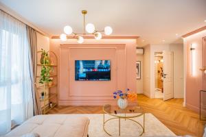 a living room with a couch and a table at Victoriei Emerald & Pink Gems - Designer Apartments in Bucharest