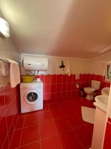 a red bathroom with a washing machine and a toilet at Apartments Villa-G Lustica in Tivat